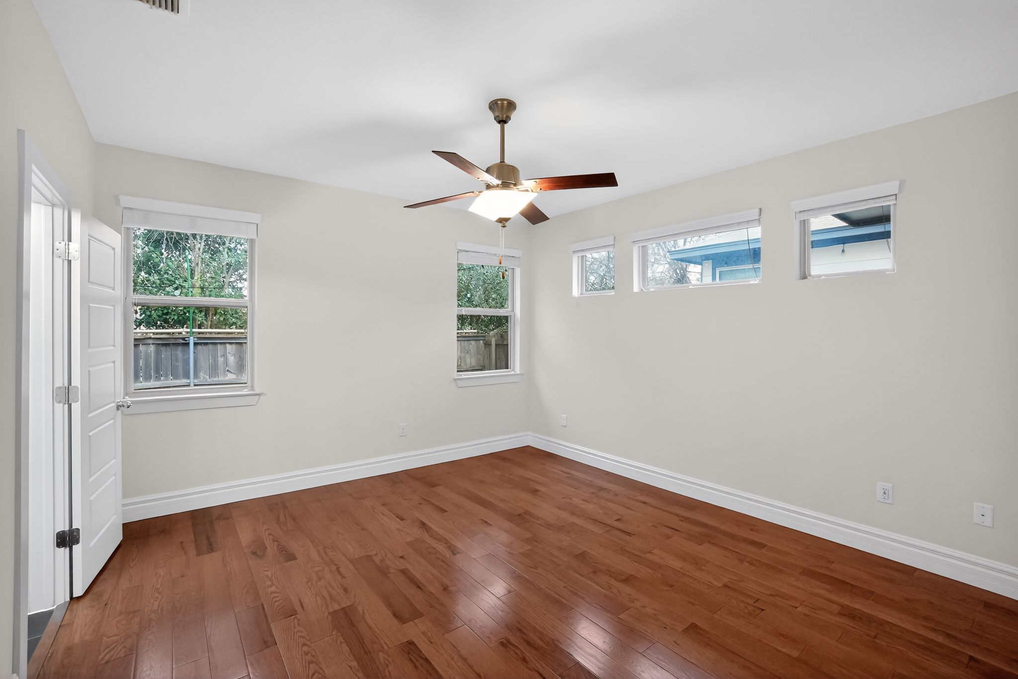 9717 Briny Shell Way Austin, TX 78748 - Photo 5 of 16 Unfurnished room featuring hardwood / wood-style flooring, healthy amount of natural light, and a ceiling fan
