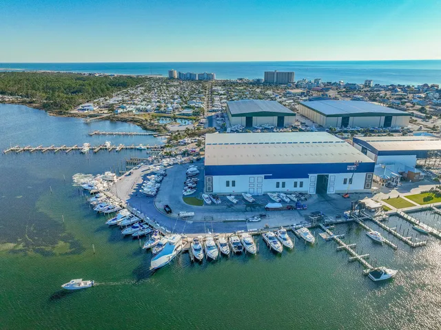 an aerial view of ocean and residential houses with outdoor space