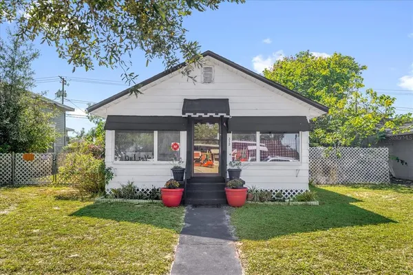 a front view of a house with garden and plants