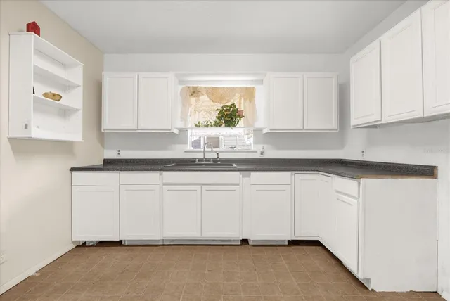 a kitchen with granite countertop white cabinets and white appliances