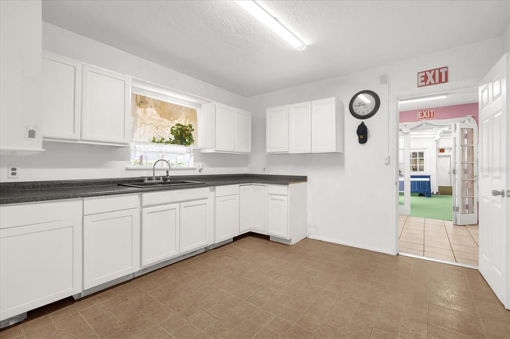 312 East Main Street Dundee, FL 33838 - Photo 14 of 27 a kitchen with granite countertop white cabinets and white appliances