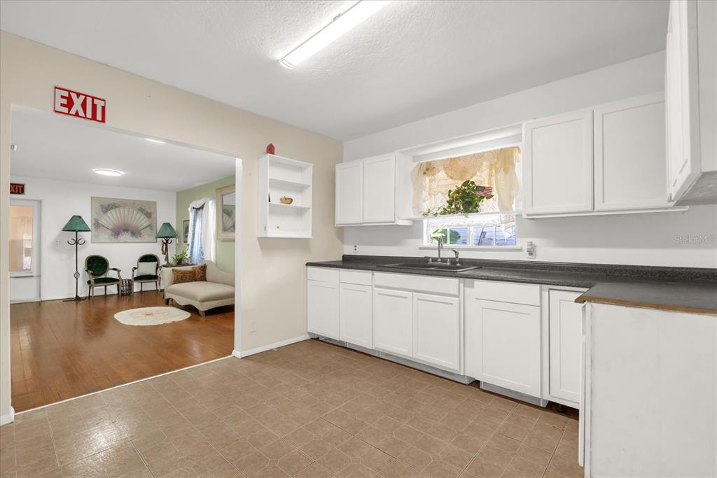 312 East Main Street Dundee, FL 33838 - Photo 15 of 27 a kitchen that has a lot of white cabinets and couches in it