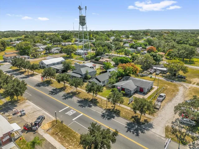 an aerial view of residential houses with outdoor space and trees