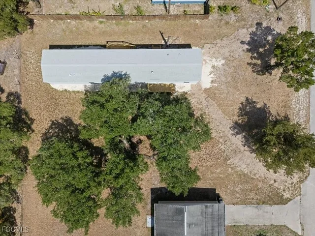an aerial view of a house with a yard and trees