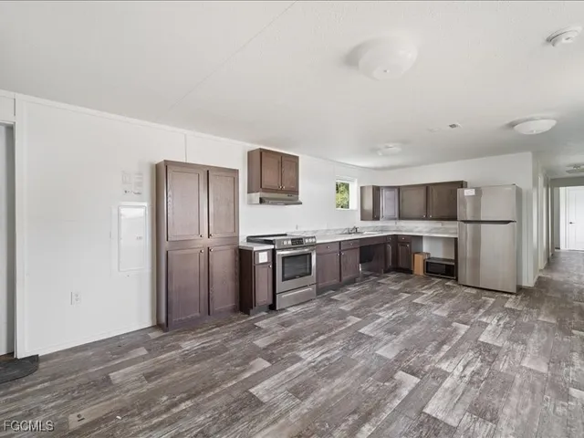 a view of a kitchen with a sink a window and stainless steel appliances