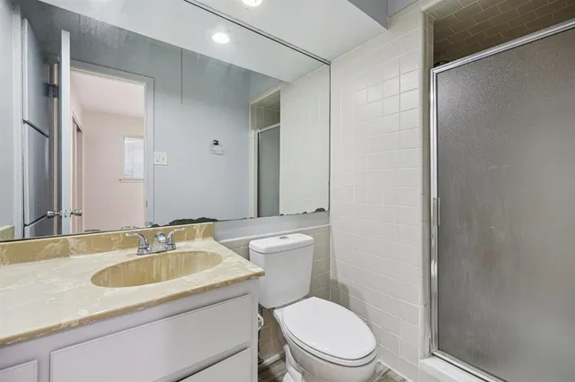 a bathroom with a sink toilet vanity and shower