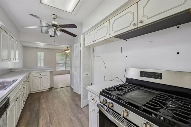 a kitchen with a stove and a wooden floor