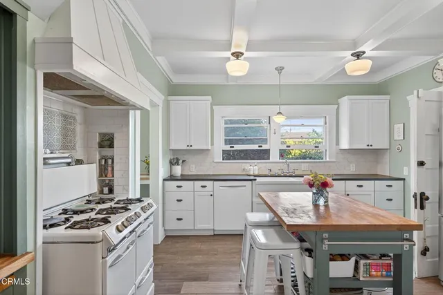 a view of a hallway to a livingroom with wooden floor and furniture