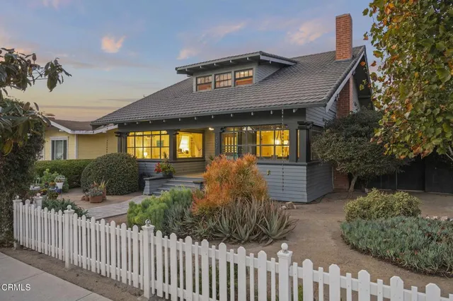 a backyard of a house with fire pit and outdoor seating
