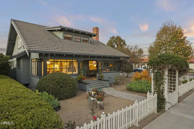 a view of a patio with table and chairs potted plants and large tree