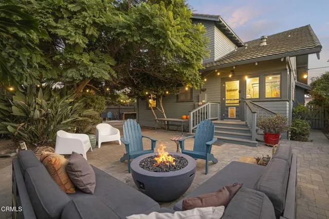 a view of a house with a small yard and wooden fence