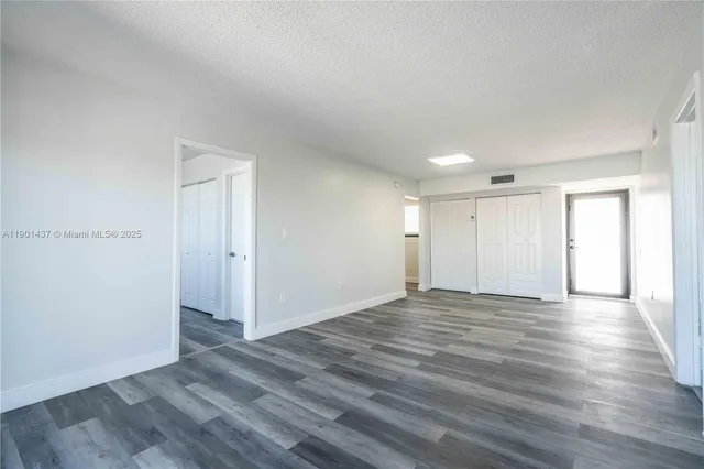 a view of an empty room with wooden floor