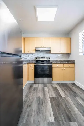 a kitchen with stainless steel appliances granite countertop a stove a sink and a refrigerator