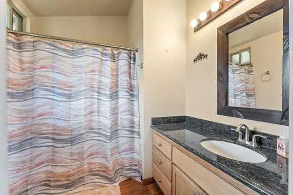 a bathroom with a granite countertop sink and a mirror