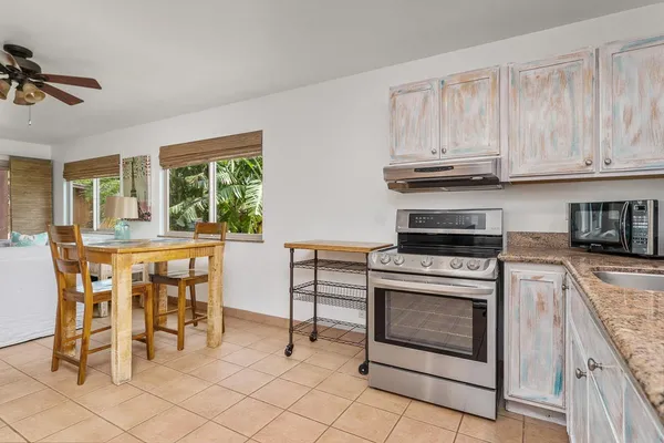 a kitchen with stainless steel appliances granite countertop a stove a sink and a refrigerator