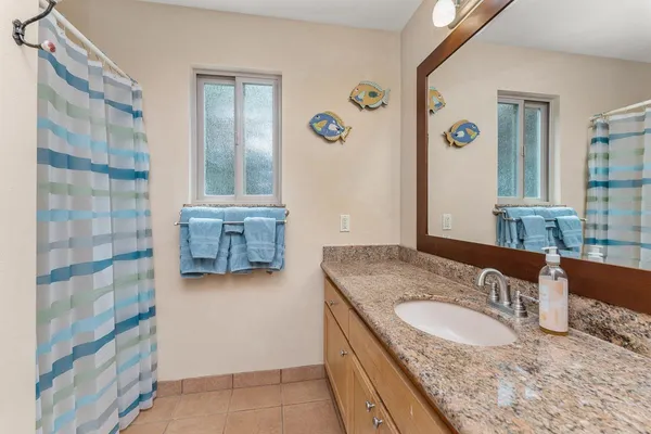 a bathroom with a granite countertop sink and a mirror