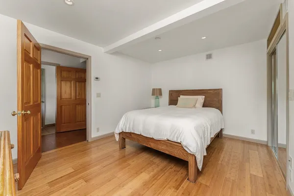 a bedroom with a bed and wooden floor