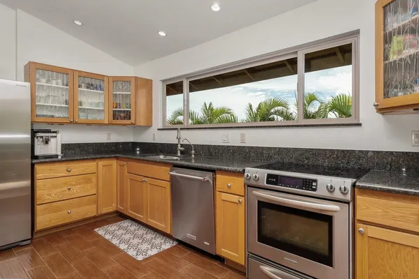 a kitchen with stainless steel appliances granite countertop a stove a sink and a microwave