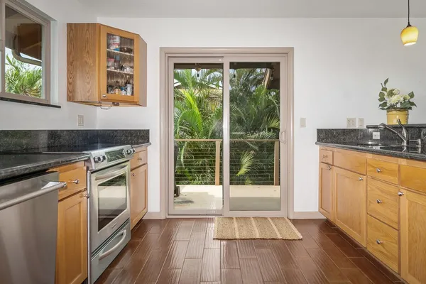 a kitchen with granite countertop a stove a sink and a refrigerator
