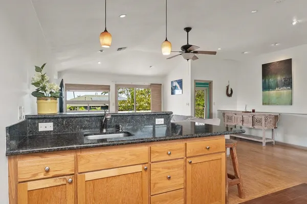 a kitchen with stainless steel appliances granite countertop a sink a counter space and a window