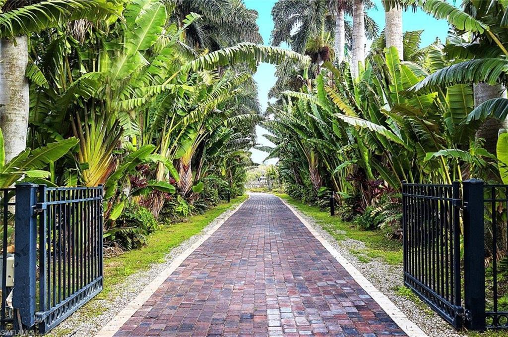 14524 Riverside Drive Fort Myers, FL 33905 - Photo 5 of 23 a view of a pathway of a park with plants and a brick wall