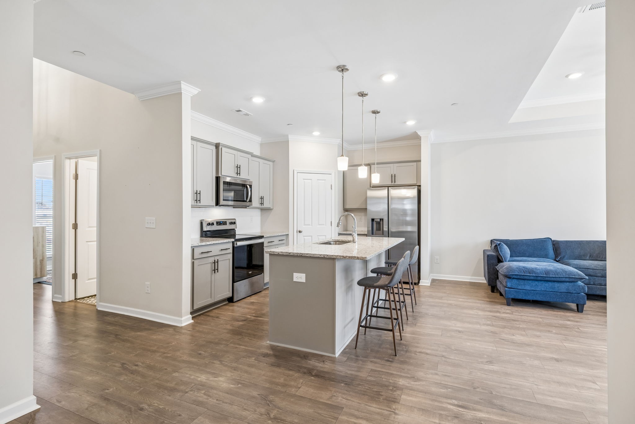 7503 Fernvale Springs Way Fairview, TN 37062 - Photo 10 of 60 a kitchen with stainless steel appliances granite countertop a stove top oven a sink dishwasher a refrigerator and a dining table with wooden floor