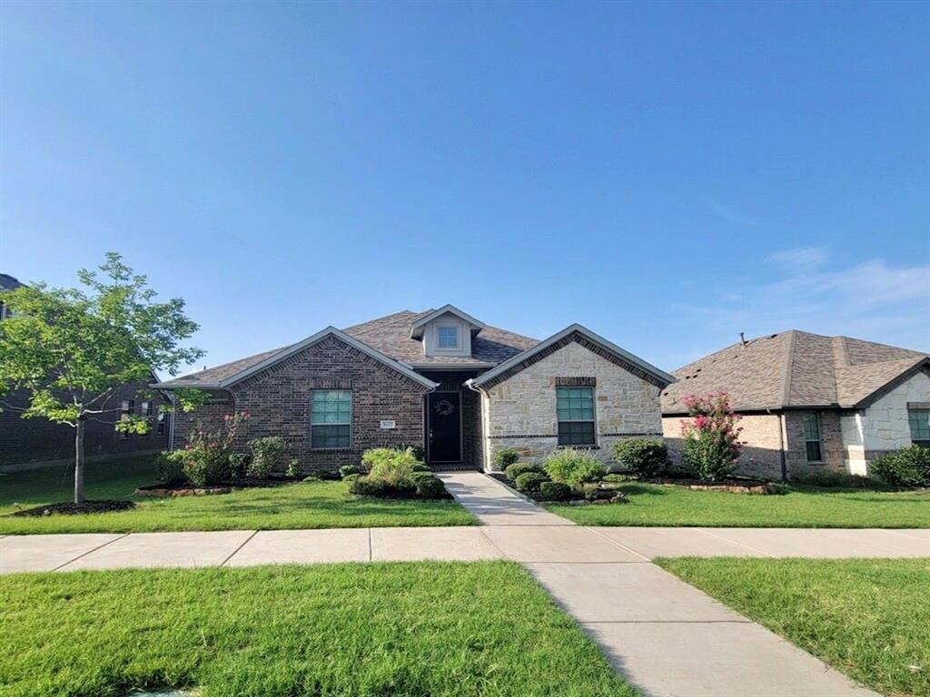 View of front of house with a front lawn, stone siding, and brick siding