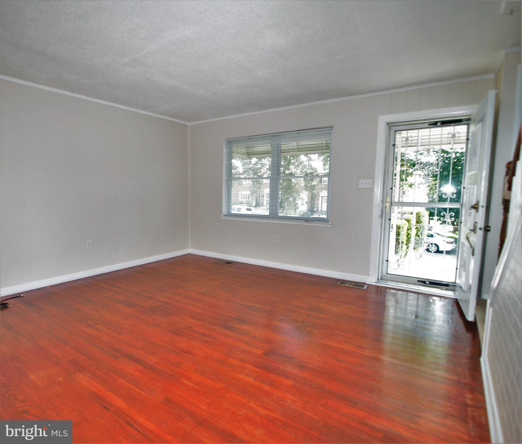 652 Charraway Road Baltimore, MD 21229 - Photo 3 of 22 an empty room with wooden floor and windows