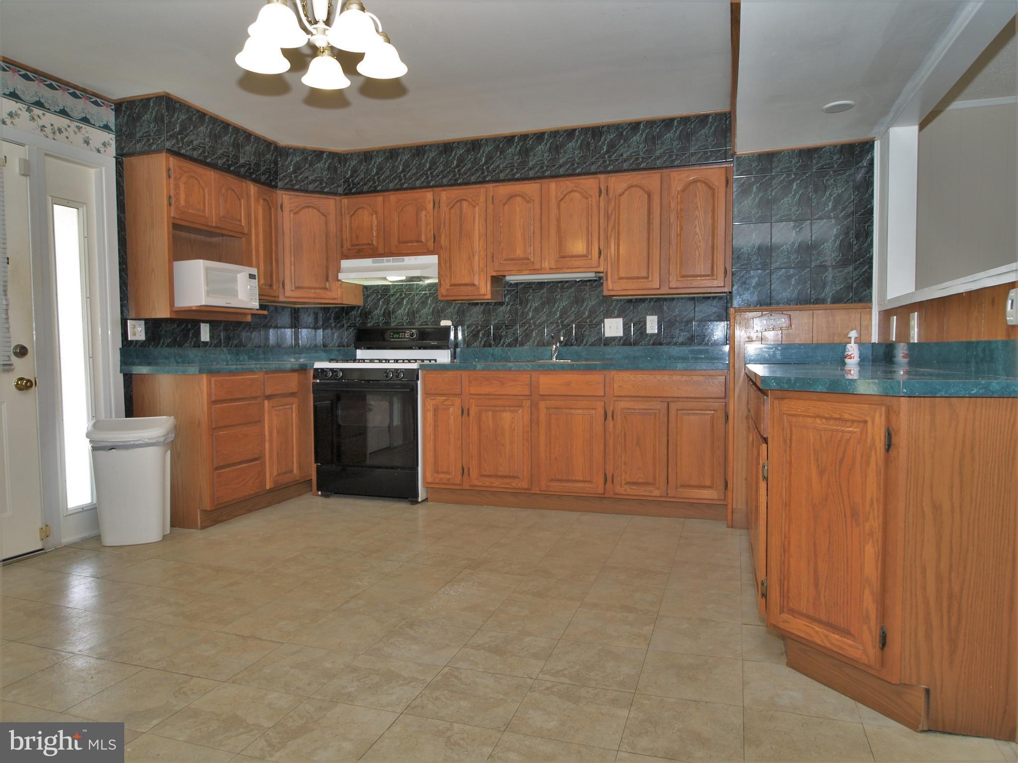 652 Charraway Road Baltimore, MD 21229 - Photo 7 of 22 a kitchen with stainless steel appliances granite countertop a stove a sink and a microwave