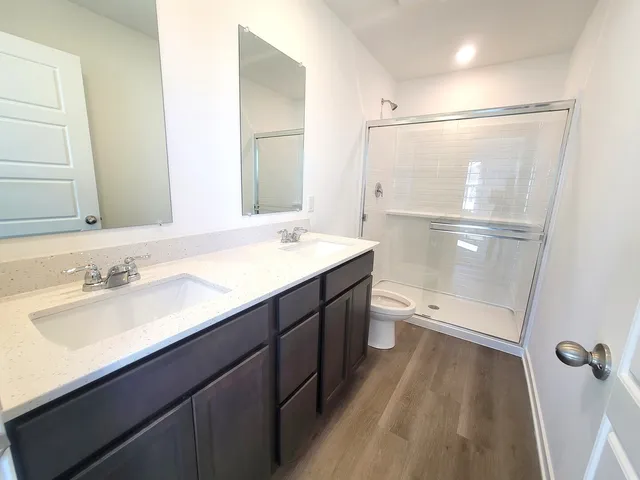 a bathroom with a sink a toilet and shower