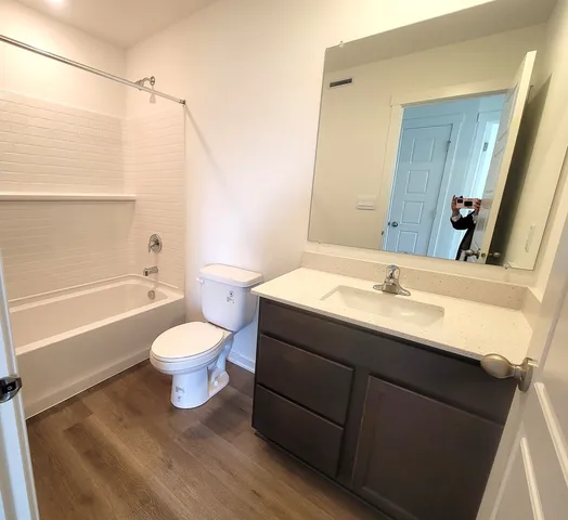 a bathroom with a sink toilet a mirror and shower