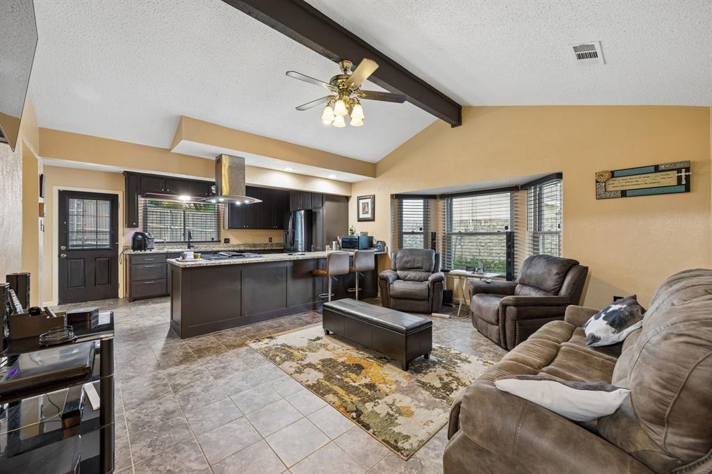2617 Quail Ridge Irving, TX 75060 - Photo 9 of 17 Vaulted ceiling with exposed beams over a kitchen and living area featuring tile flooring