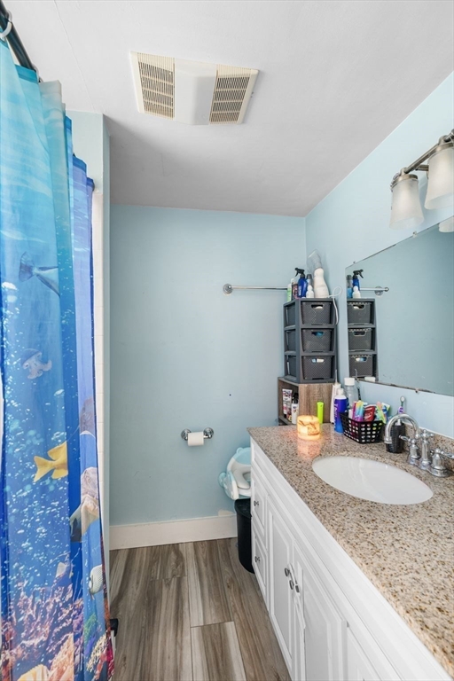 149 Elm Street Marblehead, MA 01945 - Photo 10 of 41 a bathroom with a granite countertop sink a toilet and a mirror