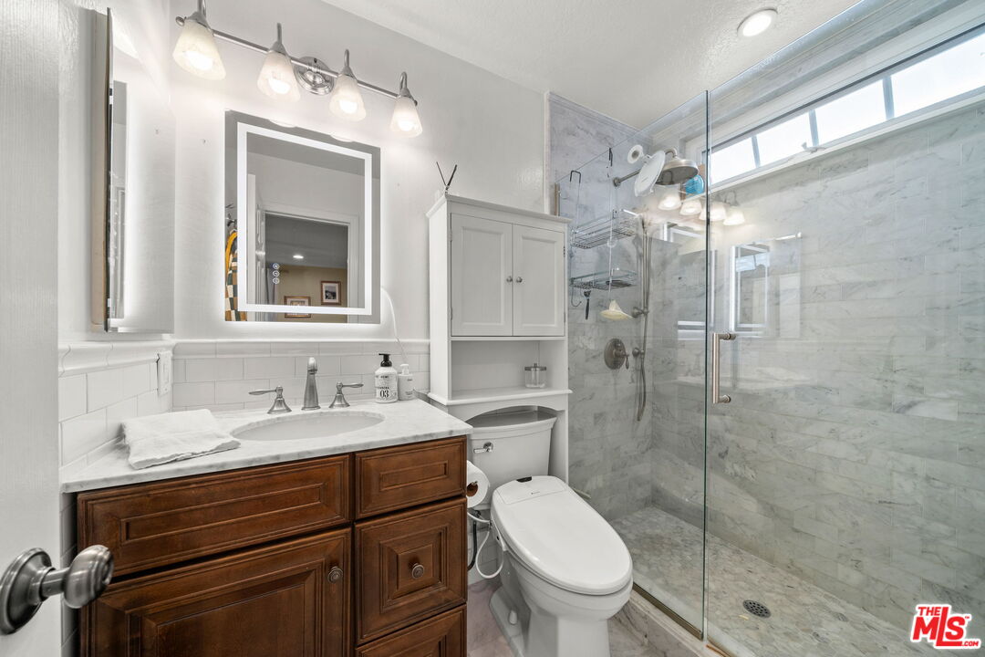 359 Termino Avenue Long Beach, CA 90814 - Photo 14 of 22 a bathroom with a sink toilet a mirror and shower