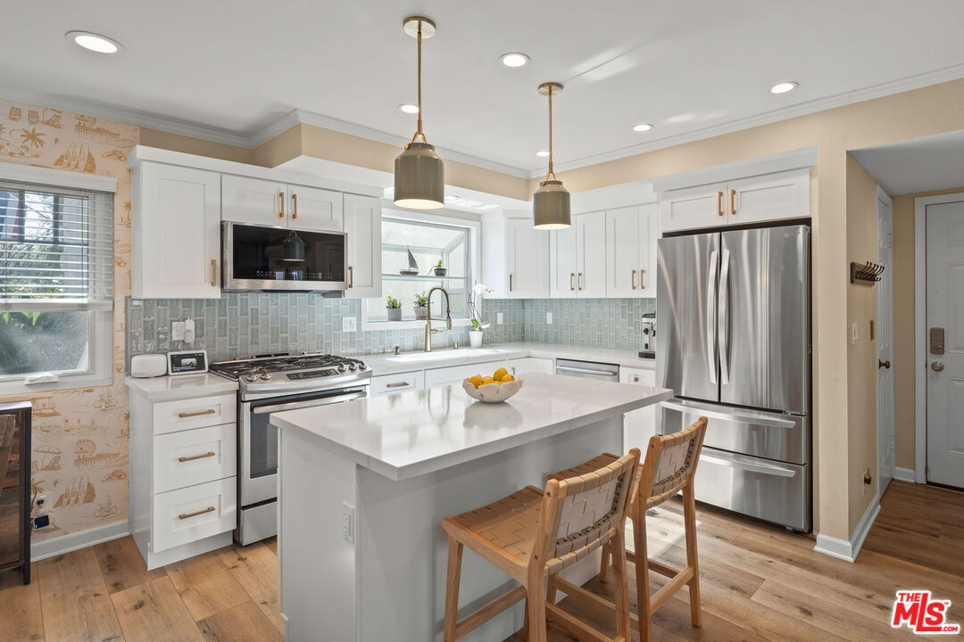 359 Termino Avenue Long Beach, CA 90814 - Photo 6 of 22 a kitchen with stainless steel appliances a stove a sink a refrigerator a center island and a stove top oven