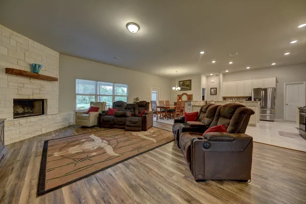 a living room with furniture kitchen view and a fireplace