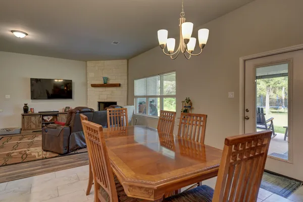 a view of a dining room with furniture a chandelier and wooden floor