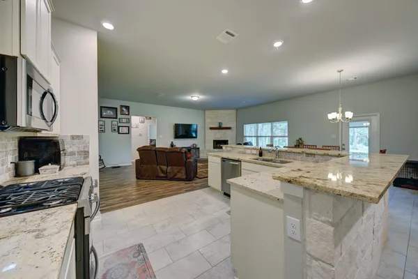 a large white kitchen with lots of counter space and stainless steel appliances