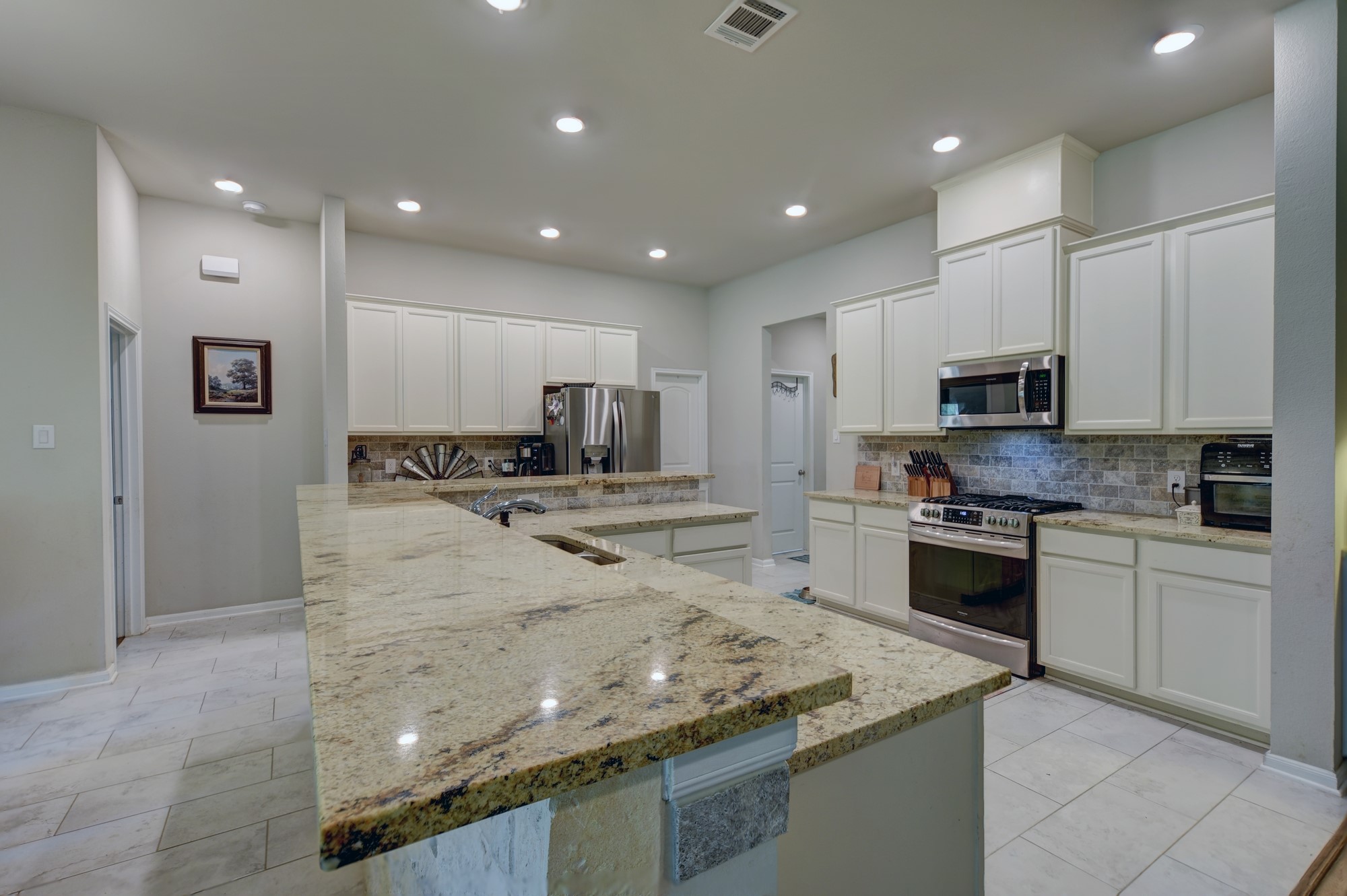 2612 Tiemann Road New Ulm, TX 78950 - Photo 17 of 39 a kitchen with kitchen island granite countertop a stove sink and microwave