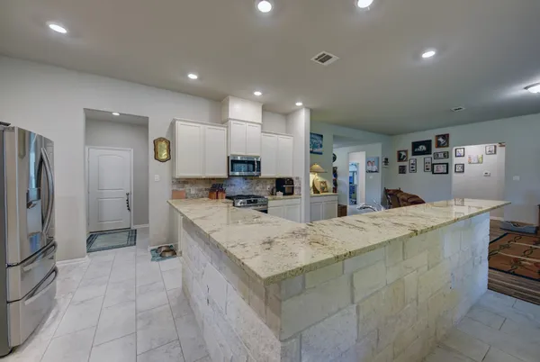 a large kitchen with stainless steel appliances lots of counter space and a sink