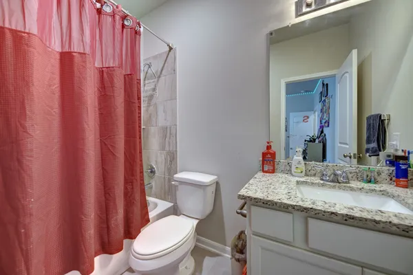 a bathroom with a granite countertop sink toilet and a mirror