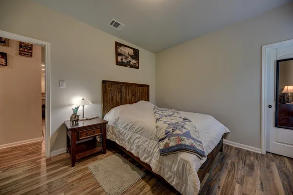 a bedroom with a bed and wooden floor