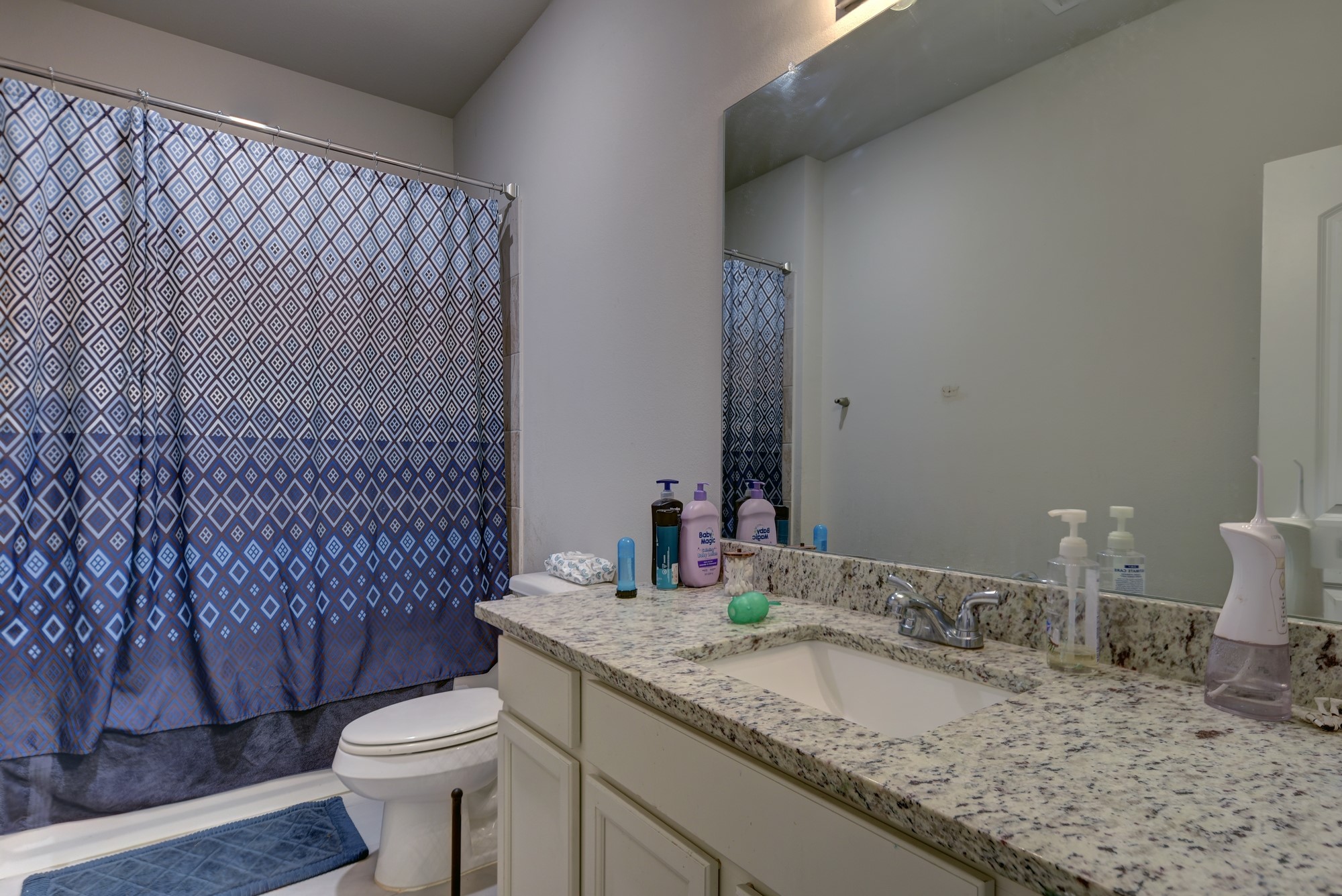 2612 Tiemann Road New Ulm, TX 78950 - Photo 27 of 39 a bathroom with a granite countertop sink mirror vanity and toilet