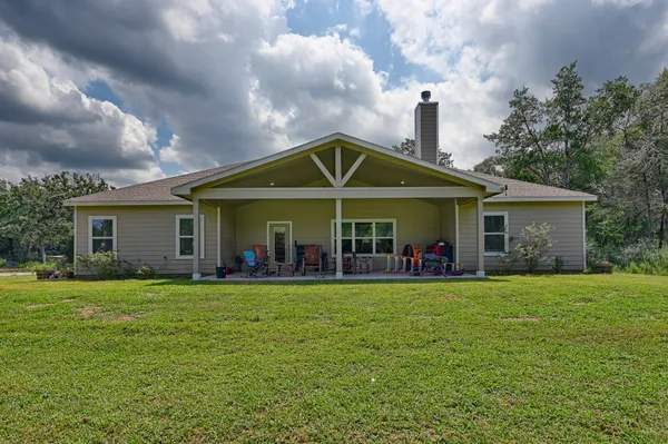 a front view of a house with a yard and trees