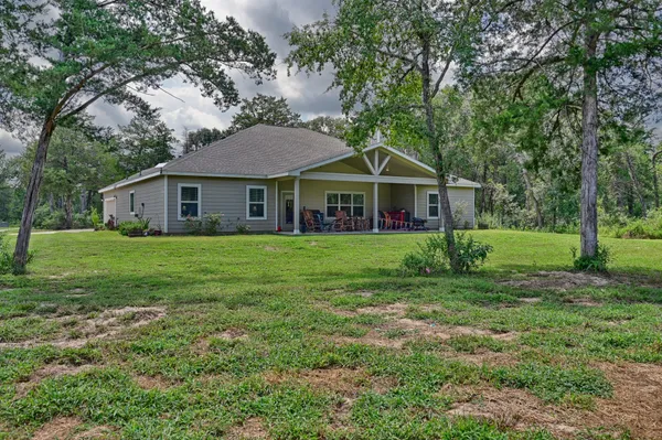 a house with green field in front of it