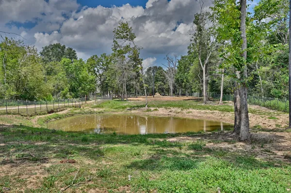 a view of a water pond with green yard