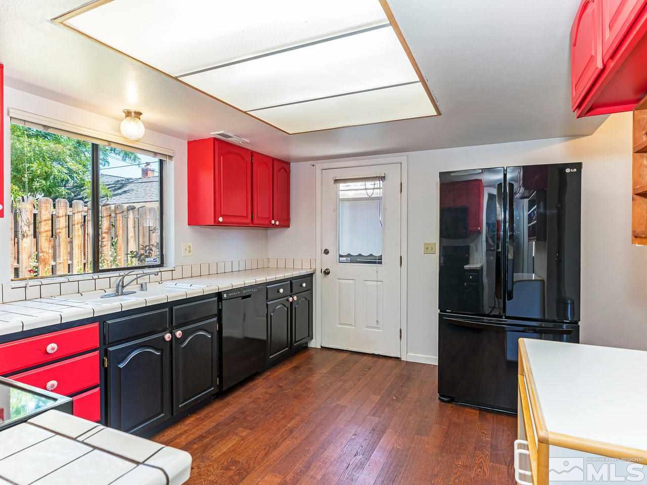 320 Caliente Street Reno, NV 89509 - Photo 11 of 17 a kitchen with a refrigerator a sink dishwasher with a kitchen island hardwood floor and a sink