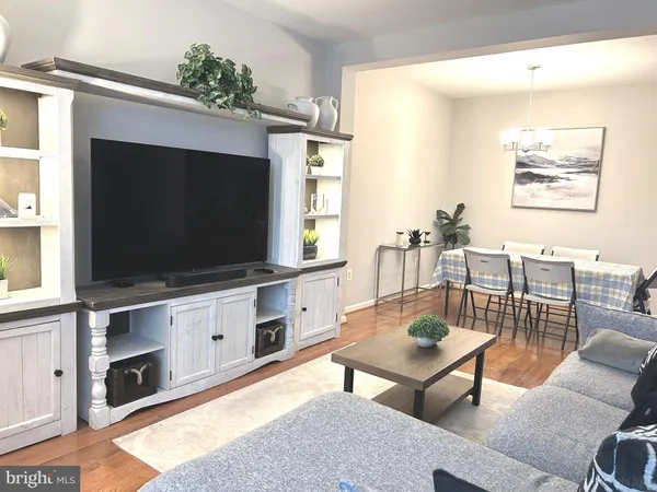 a living room with stainless steel furniture and a flat screen tv