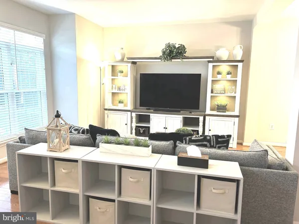 a living room with furniture flat screen tv and a large window