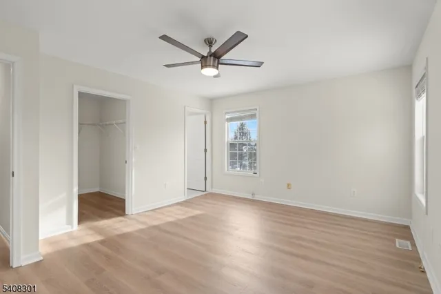 a view of a livingroom with a ceiling fan and wooden floor